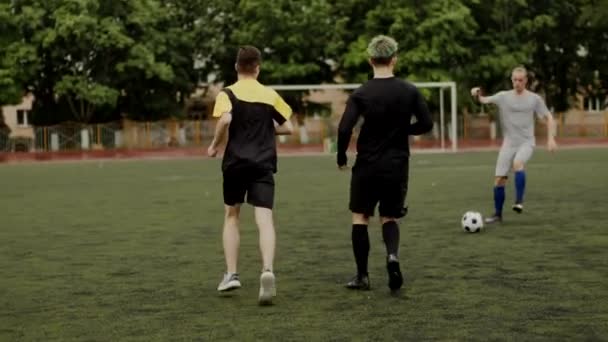 Στην προπόνηση της ποδοσφαιρικής ομάδας οι παίκτες μοιράζονται μεταξύ τους και παίζουν ποδόσφαιρο στο γήπεδο της πόλης. Αργή κίνηση - Πλάνα, βίντεο