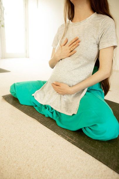 молода вагітна жінка практикує материнську йогу
 - Фото, зображення