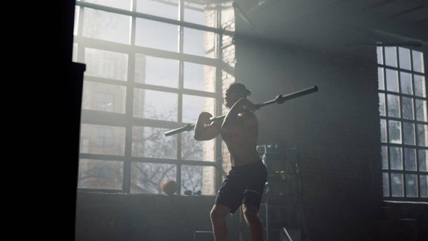 Bodybuilder fait squats avec haltère. Homme ayant un entraînement crossfit en salle de gym - Photo, image