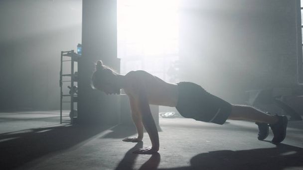 Man op de plank. Guy doet push-ups tijdens fitness sessie in sportclub - Foto, afbeelding