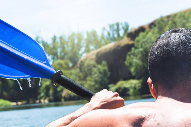 Dettaglio dell'uomo adulto che pratica uno sport acquatico nell'aria in un fiume in canoa come stile di vita sano - Foto, immagini