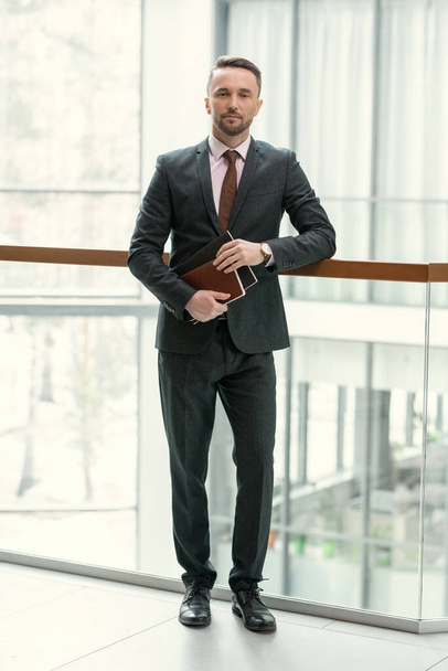 Businessman with folders standing at office - Zdjęcie, obraz