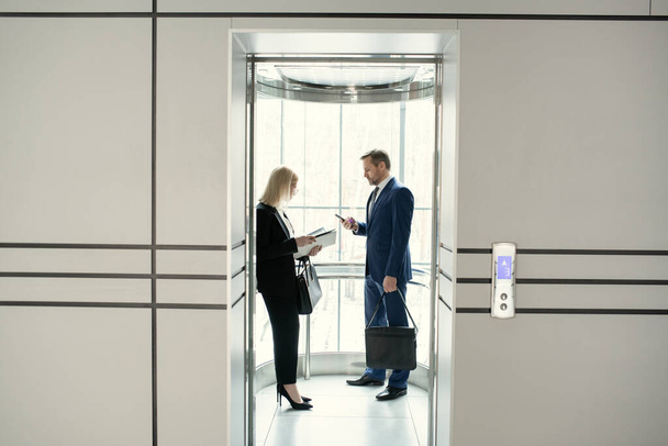 Business people standing in elevator - Valokuva, kuva