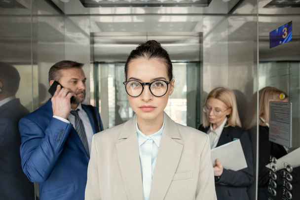 Businesswoman standing in elevator - 写真・画像