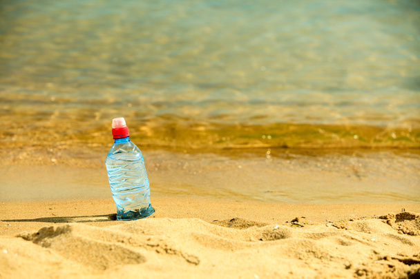 Bottle of water drink on a sandy beach. - Foto, Bild