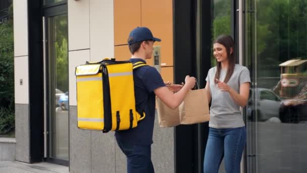 Souriant livraison de nourriture homme messager avec sac à dos thermique livrer commande femme - Séquence, vidéo