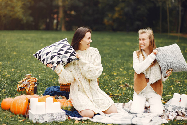 Elegant and stylish girls sitting in a autumn park - Zdjęcie, obraz