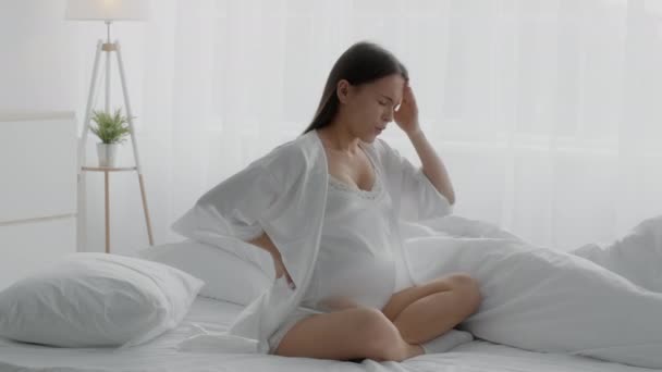 Mladá těhotná žena trpí akutní bolestí hlavy nebo migrénou doma - Záběry, video