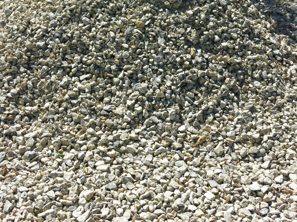 pile of small rubble, gravel lies on the road, an industrial background - Photo, Image