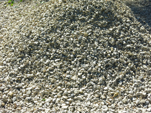 pile of small rubble, gravel lies on the road, an industrial background - Photo, Image