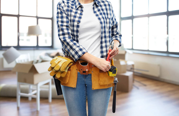 woman with working tools on belt at new home - Фото, зображення