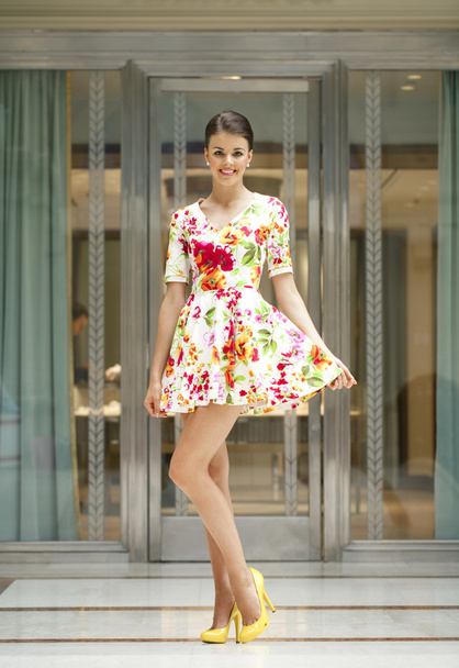 Young beautiful woman in red flowers dress  - Фото, изображение