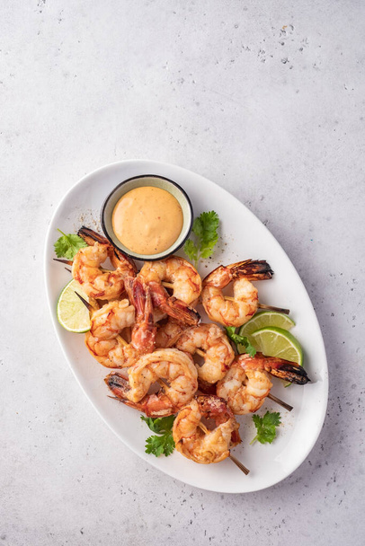 Grilled shrimps. Shrimps skewers, lime and fresh herbs - Foto, afbeelding