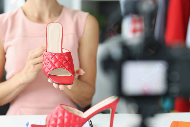 Nainen bloggaaja esittelee uusia punaisia sandaaleja kesäkokoelmasta - Valokuva, kuva