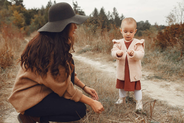 Mother with little daughter playing in a autumn field - Foto, afbeelding