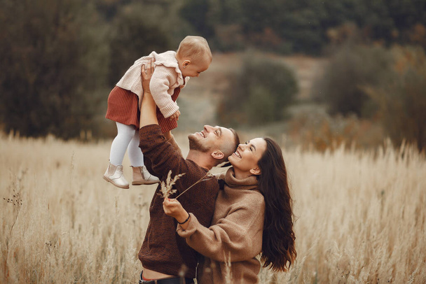 Cute and stylish family playing in a autumn field - Foto, Bild