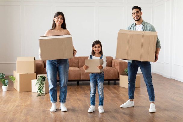 Glückliche junge Familie mit drei Holdingboxen in neuer Wohnung - Foto, Bild