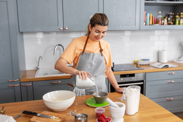 woman cooking food and baking on kitchen at home - Valokuva, kuva