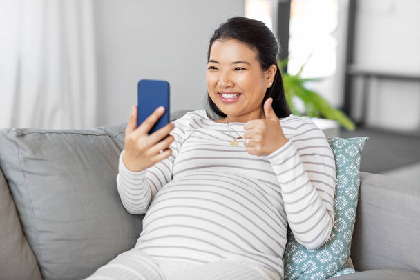 happy pregnant woman having video call on phone - Foto, Bild