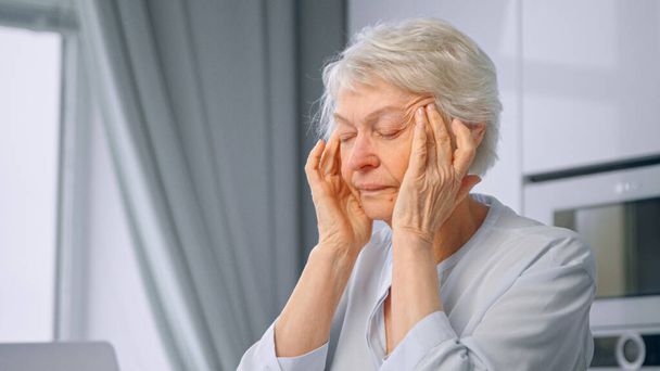 Starý unavený z práce paní důchodkyně s krátkými šedými vlasy masáže spánky s rukama - Fotografie, Obrázek