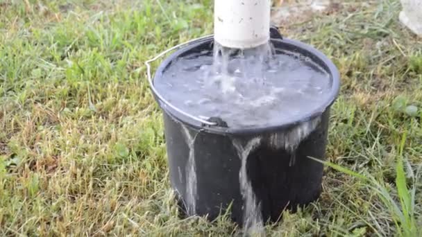 A água está derramando da casa para o aguaceiro no balde - Filmagem, Vídeo