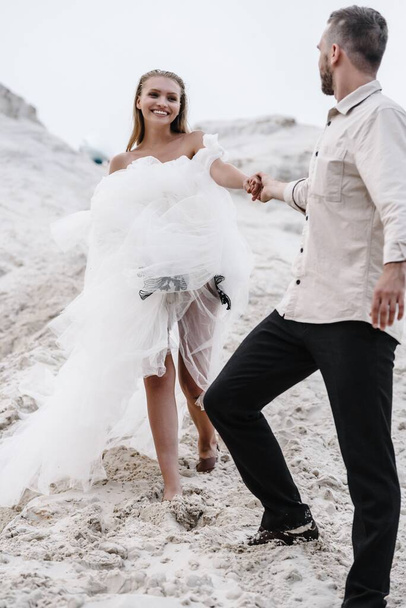 Piękny ślub para panna młoda i pan młody w dniu ślubu na zewnątrz na plaży ocean. Szczęśliwe małżeństwo - Zdjęcie, obraz