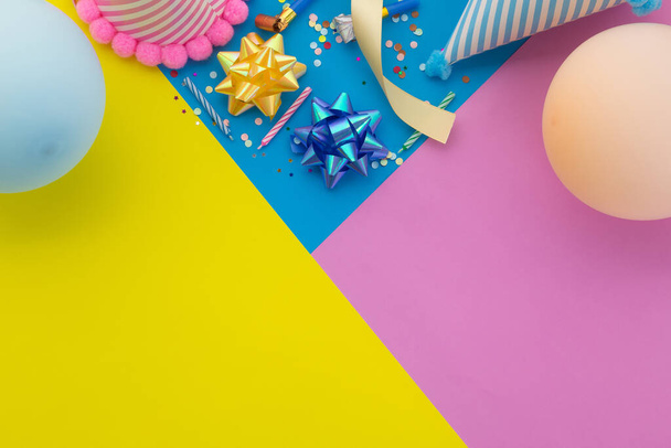 Χρόνια πολλά φόντο, επίπεδη lay πολύχρωμο διακόσμηση κόμμα σε παστέλ κίτρινο, μπλε και ροζ γεωμετρικό φόντο. - Φωτογραφία, εικόνα
