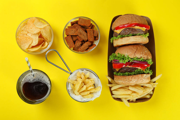 Konzept von Fast Food auf gelbem Hintergrund - Foto, Bild