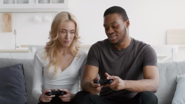 Petit ami africain expliquant mécontent petite amie comment jouer au jeu vidéo à la maison - Séquence, vidéo