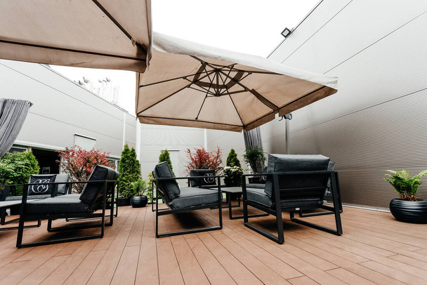 терраса с зонтиками, диваном, креслами, столом - Фото, изображение