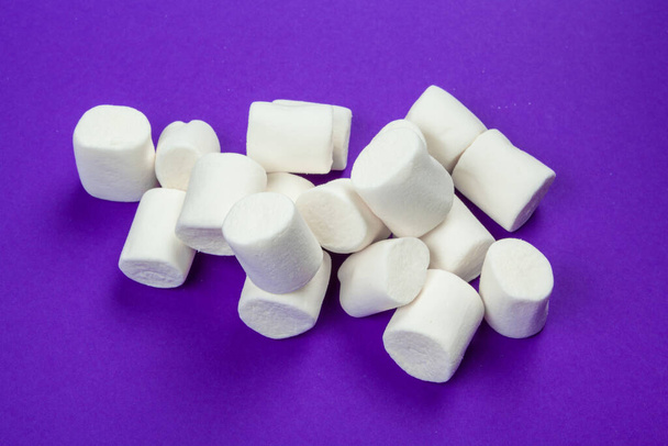 marshmallow disposti su sfondo di carta viola. - Foto, immagini