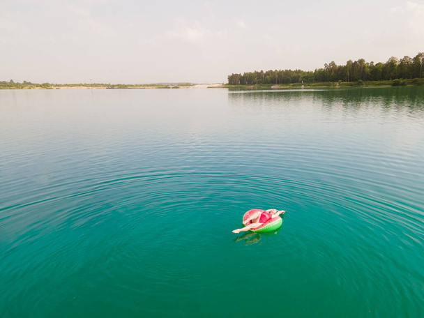 jeune femme heureuse flottant dans l'eau bleue azur sur anneau gonflable cercle vacances d'été - Photo, image