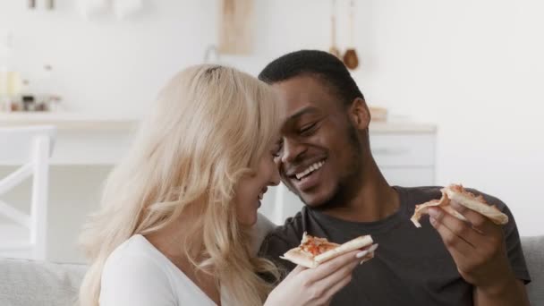 Boldog vegyes pár eszik Pizza Flörtölés és nevetés otthon - Felvétel, videó