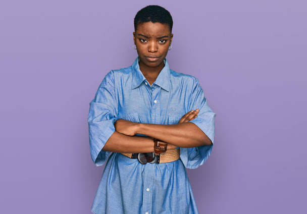 Młoda Afroamerykanka w luźnych ciuchach, sceptyczna i nerwowa, nie pochwalająca wyrazu twarzy z skrzyżowanymi ramionami. osoba negatywna.  - Zdjęcie, obraz
