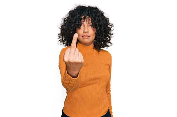 Young hispanic woman wearing casual clothes showing middle finger, impolite and rude fuck off expression  - Foto, imagen
