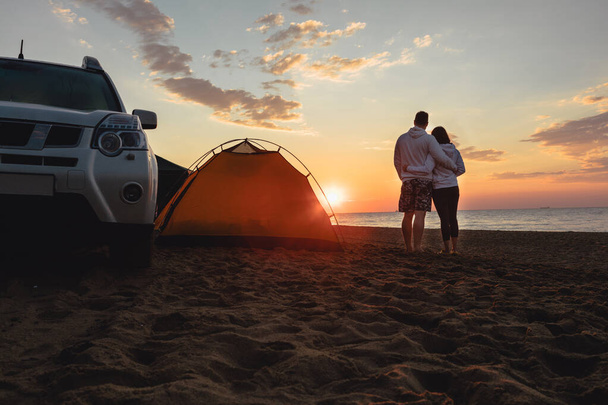 Paar beim Sonnenaufgang. Camping-Lebensstil. Geländewagen. gelbes Zelt - Foto, Bild