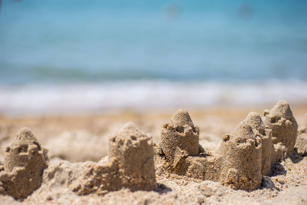 Castillo de arena de pie en la playa. Concepto de vacaciones de viaje. - Foto, Imagen