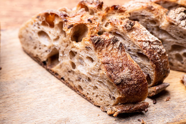 Pieces of buckwheat bread. Sliced baguette on a wooden board. - Foto, Bild