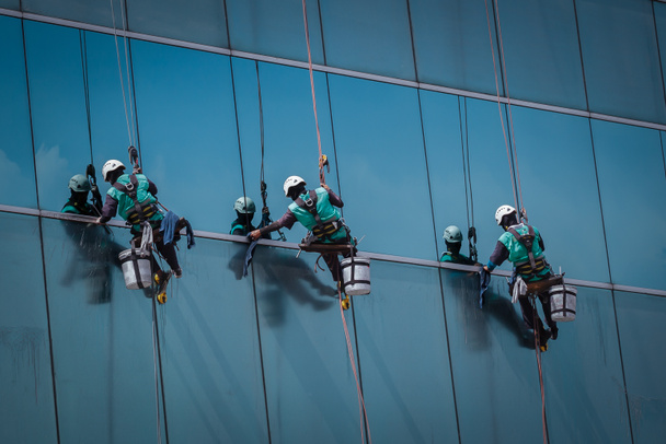 група робітників, які прибирають вікна на висотній будівлі
 - Фото, зображення