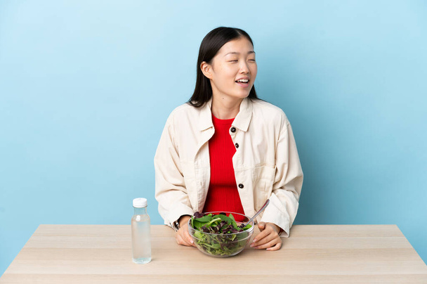 Nuori kiinalainen tyttö syö salaatti nauraa - Valokuva, kuva