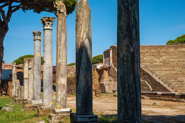 Panorama of the excavations of Ostia Antica, Rome Italy. Detail of the marble columns in the theater of the archaeological park of Ostia with the steps of the imperial era, in summer with sky. Italy. - Photo, Image