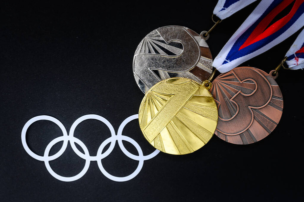 TOKYO, JAPAN, JULY. 19. 2021: Medal set, gold silver and bronze and olympic logo on black background. Medal Table concept photo - Foto, imagen