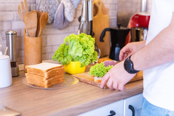 άνθρωπος κάνει σάντουιτς στην κουζίνα αντίγραφο χώρο - Φωτογραφία, εικόνα
