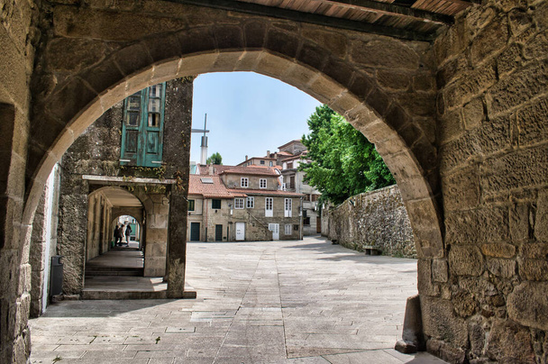 A beautiful shot of the square through the medieval stone arch in Pontevedra, Spain - Valokuva, kuva