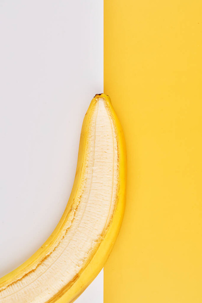 Creative geometric background with bananas. Yellow white backdrop wallpaper - 写真・画像