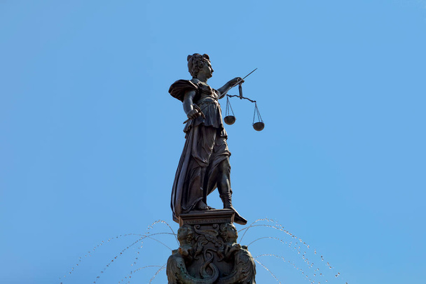 Pani sprawiedliwość w Roemer we Frankfurcie nad Menem symbolizuje sprawiedliwość mieczem i łuskami pod błękitnym niebem. - Zdjęcie, obraz