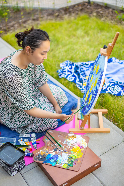 Asiática joven pintura imagen en casa terraza - Foto, Imagen