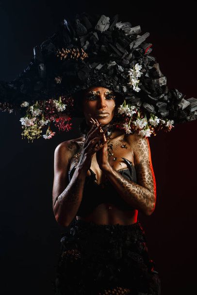 Portrait of a model in a headdress and dress made of coal. - Фото, изображение