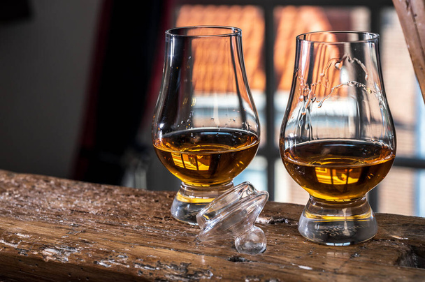 Dram de whisky escocés de malta simple servido en vidrio de degustación con vista a la ventana vieja y casas en viga de madera - Foto, imagen
