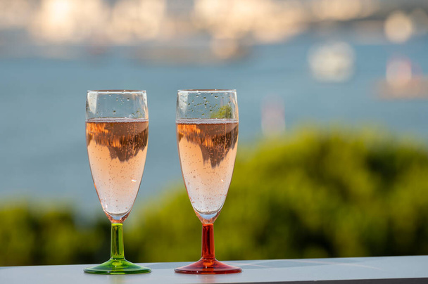Festa de verão, beber vinho espumante de champanhe rosa francês em copos com vista para os pescadores e porto militar de Toulon, França - Foto, Imagem